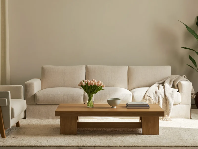 Canapé trois places en tissu, fauteuil, plaid et table basse en bois